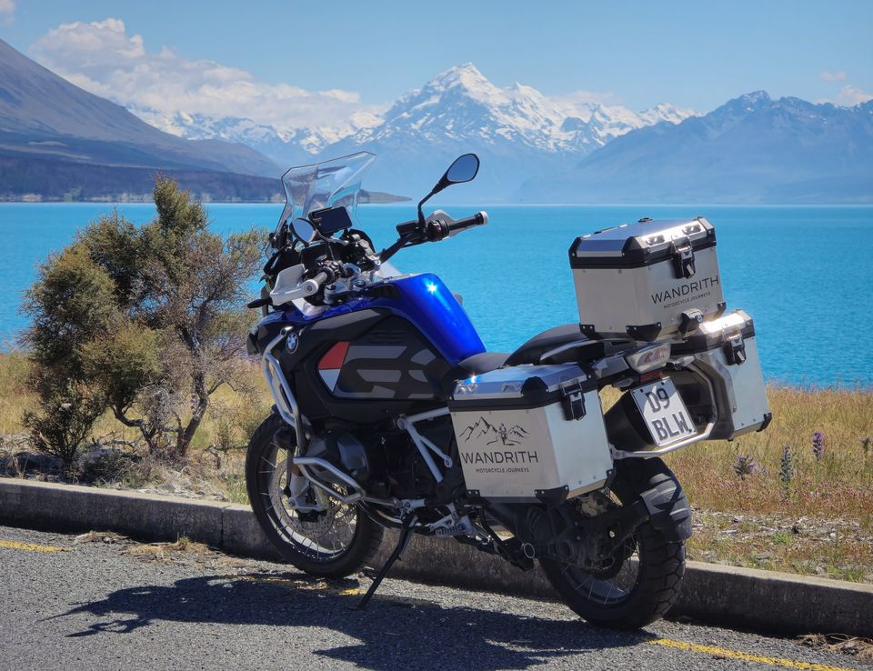 BMW R 1250 GS Adventure with Wandrith panniers parked above turquoise Lake Pūkaki, snowy Aoraki / Mount Cook beyond
