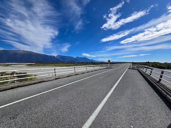 Narrow road bridge with blue skies and cloud